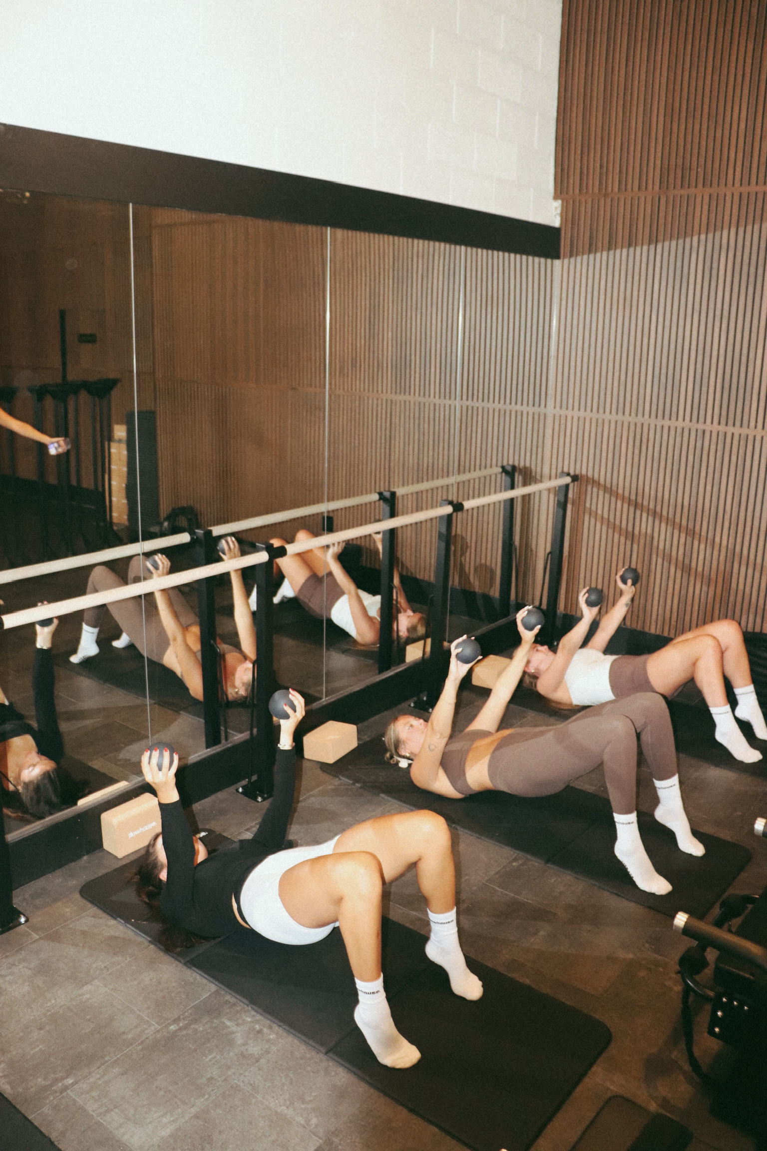 One of the two barre walls installed at flowhouse — wooden barre on black hardware against a glass partition