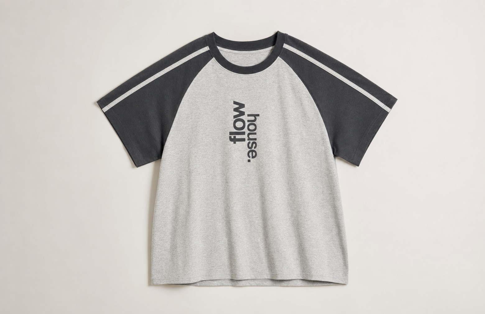 The Flow Raglan tee in heather gray with charcoal sleeves.