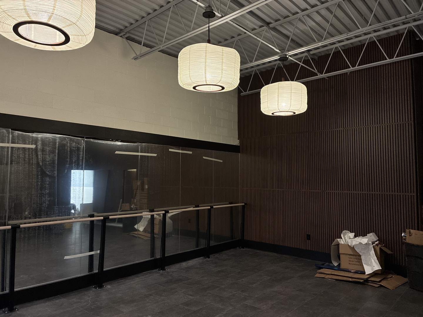 Close-up of the pendant lanterns and walnut feature wall during the flowhouse build.